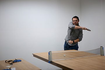Our Director of Engineering playing ping pong at the office gaming area
