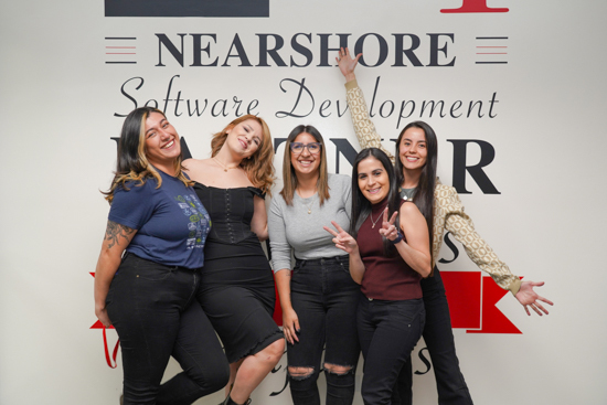 Our recruitment team standing in front of the 'Nearshore' wall at the office, happy to receive your referrals